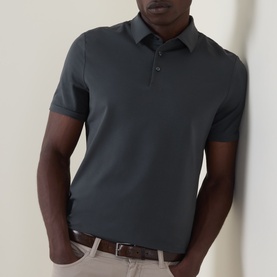 Model wearing Boggi Milano dark green cotton polo shirt with three-button placket and short sleeves, styled with beige trousers