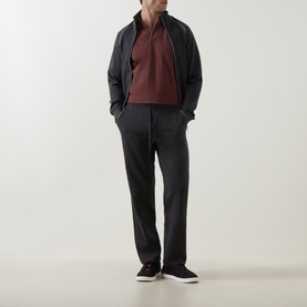 Model wearing Boggi Milano Brick Red polo, styled with charcoal zip-up jacket, matching trousers, and dark slip-on trainers.