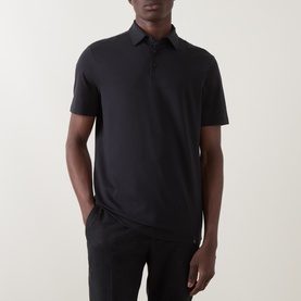 Model wearing Boggi Milano Supima Solid Polo Shirt in black, with polo collar, short sleeves and button fastenings, styled with black trousers.