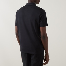 Model wearing Boggi Milano Supima Solid Polo Shirt in black, rear view, polo collar, short sleeves, paired with black trousers.