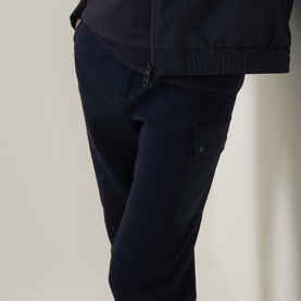 Model wearing Boggi Milano Light Scuba Cargo Sweatpants in navy blue, styled with a matching navy zip-up top. Cargo pocket visible.