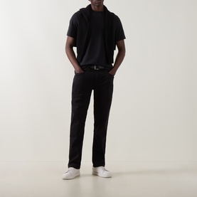 Model wearing Boggi Milano Supima Solid T-Shirt in black with round neck, styled with black trousers, belt and white trainers.