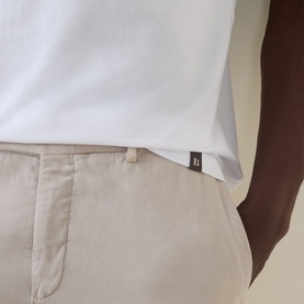 Model wearing Boggi Milano white cotton T-shirt, shown with small branded tab detail, styled with stone beige chinos.