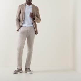 Model wearing Boggi Milano white cotton T-shirt, styled with beige blazer, taupe trousers and slip-on shoes.
