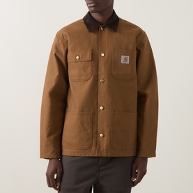 Model wearing Carhartt Hamilton Brown casual jacket with dark corduroy collar, gold snap buttons, and chest pockets