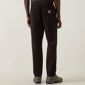 Model wearing Carhartt Casual Trousers in Tobacco brown corduroy, styled with green trail shoes, rear view.