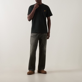 Model wearing Carhartt Crew Neck T in Raven black with khaki cargo trousers and tan shoes.
