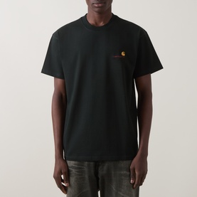 Model wearing Carhartt Crew Neck T in Raven black with small embroidered chest logo detail in orange and red.