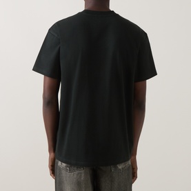 Model wearing Carhartt Crew Neck T in Raven black, rear view, short sleeves, styled with grey distressed jeans.