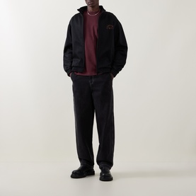 Model wearing Carhartt Logo Chest Pocket T-Shirt in Amarone, styled with black zip jacket, dark trousers and black leather shoes.