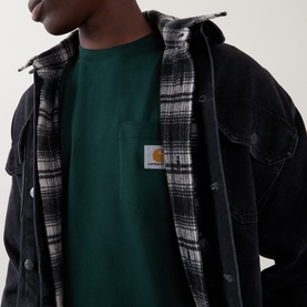 Model wearing Carhartt Dark Scarab crew neck T-shirt, styled under a black plaid-lined jacket with chest pocket detail.