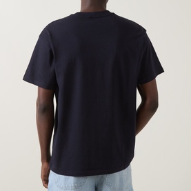 Model wearing Carhartt Crew Neck T in Dark Navy, rear view, styled with light blue jeans.