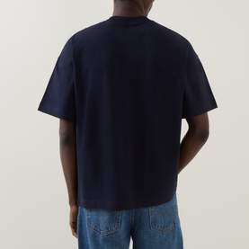 Model wearing Carhartt Signature Script Logo T-Shirt in Dark Navy, back view, with light-wash jeans. Crew neck, short sleeves, straight hem.