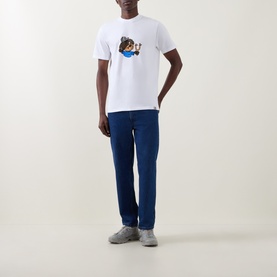 Model wearing Carhartt white crew neck T-shirt with graphic print, styled with blue straight-leg jeans and grey trainers.