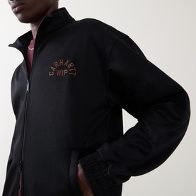 Model wearing Carhartt WIP black zip-through sweat with embroidered logo chest detail, styled with a pink crew neck underneath.