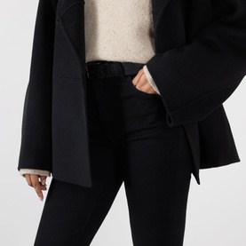 Model wearing FRAME DENIM Reboot Bootcut Jeans in black, high-rise with belt loops, styled with a black blazer and cream knit.