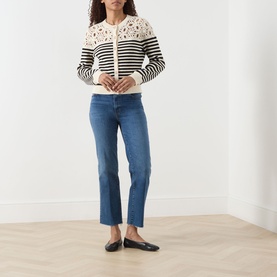 Model wearing FRAME DENIM The Coastal Striped Cardigan in Cream Multi with crochet shoulders, styled with blue cropped jeans and black flats.