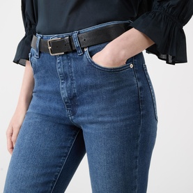 Model wearing FRAME DENIM Crop Boot jeans in Sonnet blue denim, styled with a black top and leather belt.