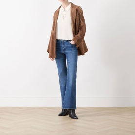 Model wearing FRAME DENIM Flare Jeans in Provence mid-blue denim, styled with a brown suede blazer, cream top and black ankle boots.