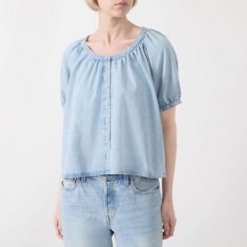 Model wearing FRAME DENIM shirt in Haven blue, puff short sleeves, gathered scoop neck with button placket, styled with light wash jeans.