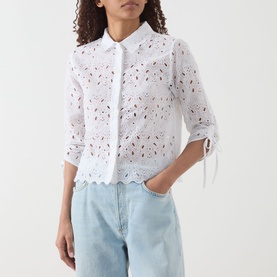 Model wearing FRAME DENIM The Paisley Eyelet Cinch-Sleeve Shirt in white with scalloped hem and cinched sleeves, styled with light blue jeans.