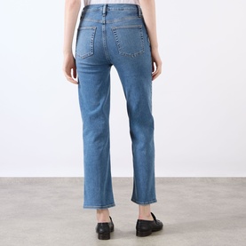 Model wearing FRAME DENIM Straight Jeans in Gossamer blue, rear view showing back pockets and cropped straight leg, styled with black loafers