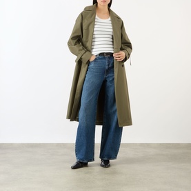 Model wearing FRAME DENIM The Bow High-Rise Wide Leg Jeans in Obscura, styled with a striped top, khaki trench coat and black loafers.