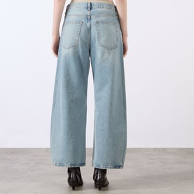 Model wearing FRAME DENIM Straight Jeans in Coastal light blue wash, wide-leg cut, back view, styled with black ankle boots