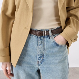 Model wearing FRAME DENIM Coastal straight jeans in light blue denim, styled with a brown leather belt and camel blazer.