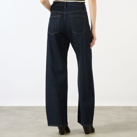 Model wearing FRAME DENIM The Off Duty Drawstring Bow High-Rise Barrel Jeans in Rinse, showing rear view of wide-leg silhouette and five-pocket style.