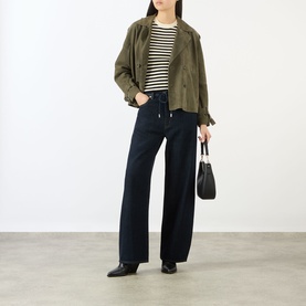 Model wearing FRAME DENIM The Off Duty Drawstring Bow High-Rise Barrel Jeans in Rinse, styled with olive jacket, striped top and black heeled boots.
