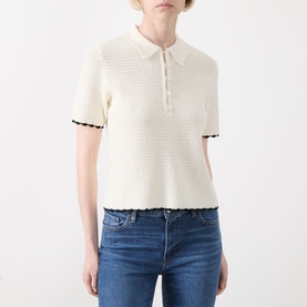 Model wearing FRAME DENIM cream multi textured knit polo top with black trim detail, styled with blue denim jeans.