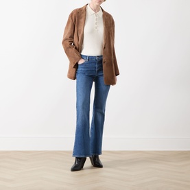 Model wearing FRAME DENIM cream multi top, styled with brown blazer, blue flare jeans and black ankle boots.