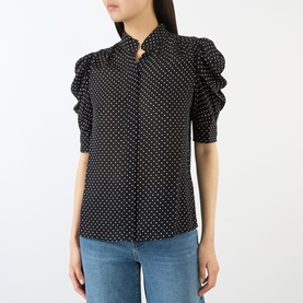 Model wearing FRAME DENIM Gillian Polka Dot Blouse in Black Multi silk, with standing collar and elbow-length puff sleeves, styled with blue jeans