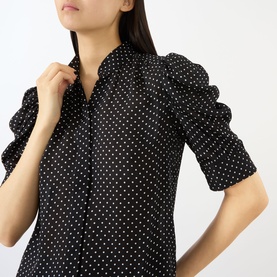 Model wearing FRAME DENIM Gillian Polka Dot Blouse in Black Multi silk, featuring standing collar and elbow-length puff sleeves