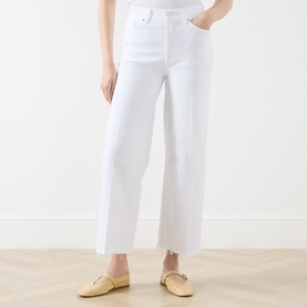 Model wearing FRAME DENIM Wide Leg Jeans in White Raw Fray with raw fray hem, styled with yellow ballet flats.