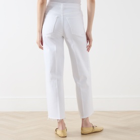 Model wearing FRAME DENIM Wide Leg Jeans in White Raw Fray, rear view showing frayed hem and relaxed fit, styled with tan loafers