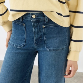 Model wearing FRAME DENIM Le Slim Palazzo High-Rise Wide Leg Jeans in Archive, featuring modernist front pockets and tobacco stitching, styled with a