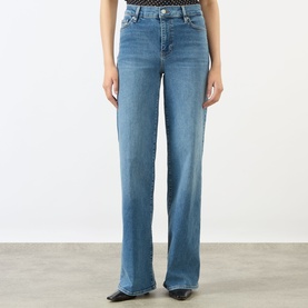 Model wearing FRAME DENIM Le Slim Palazzo High-Rise Wide Leg Jeans in Gossamer blue with whiskering, faded details and tobacco stitching.