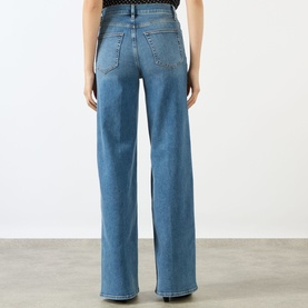 Model wearing FRAME DENIM Le Slim Palazzo High-Rise Wide Leg Jeans in Gossamer, rear view showing five-pocket style and tobacco stitching.