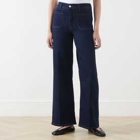 Model wearing FRAME DENIM Le Slim Palazzo Wide-Leg Jeans in Rinse, high-rise with front patch pockets and pressed creases, styled with black ballet
