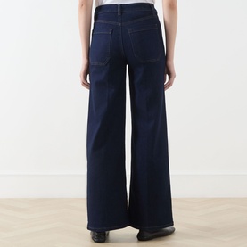 Model wearing FRAME DENIM Le Slim Palazzo Wide-Leg Jeans in Rinse, showing rear view with patch pockets and wide-cut leg silhouette