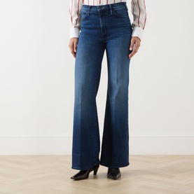 Model wearing Mother Jeans in Homecoming High, wide-leg flare cut, styled with a striped shirt and black heeled boots