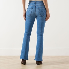 Model wearing Mother jeans in Piece By Piece blue denim, rear view showing flared leg, back pockets, with brown heeled boots