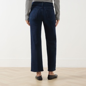 Model wearing Mother Jeans in Chip On My Shoulder dark indigo wash, wide-leg fit, rear view. Styled with striped top and black loafers.