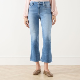 Model wearing Paige Crop Boot jeans in Cinerama light blue denim, styled with a blush pink top and taupe loafers.