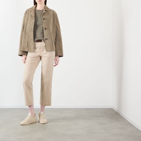Model wearing Paige Vintage Warm Sand straight jeans styled with a khaki jacket, olive top and cream trainers.
