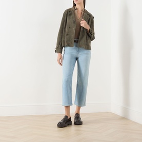 Model wearing Paige Coliseum straight-leg jeans in light blue denim, styled with an olive military jacket and black chunky loafers.