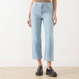 Model wearing Paige straight-leg jeans in Coliseum light blue denim, cropped length, styled with black chunky loafers.