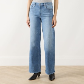Model wearing Paige straight jeans in Cinerama blue denim, wide-leg fit with faded wash, styled with black heeled ankle boots.